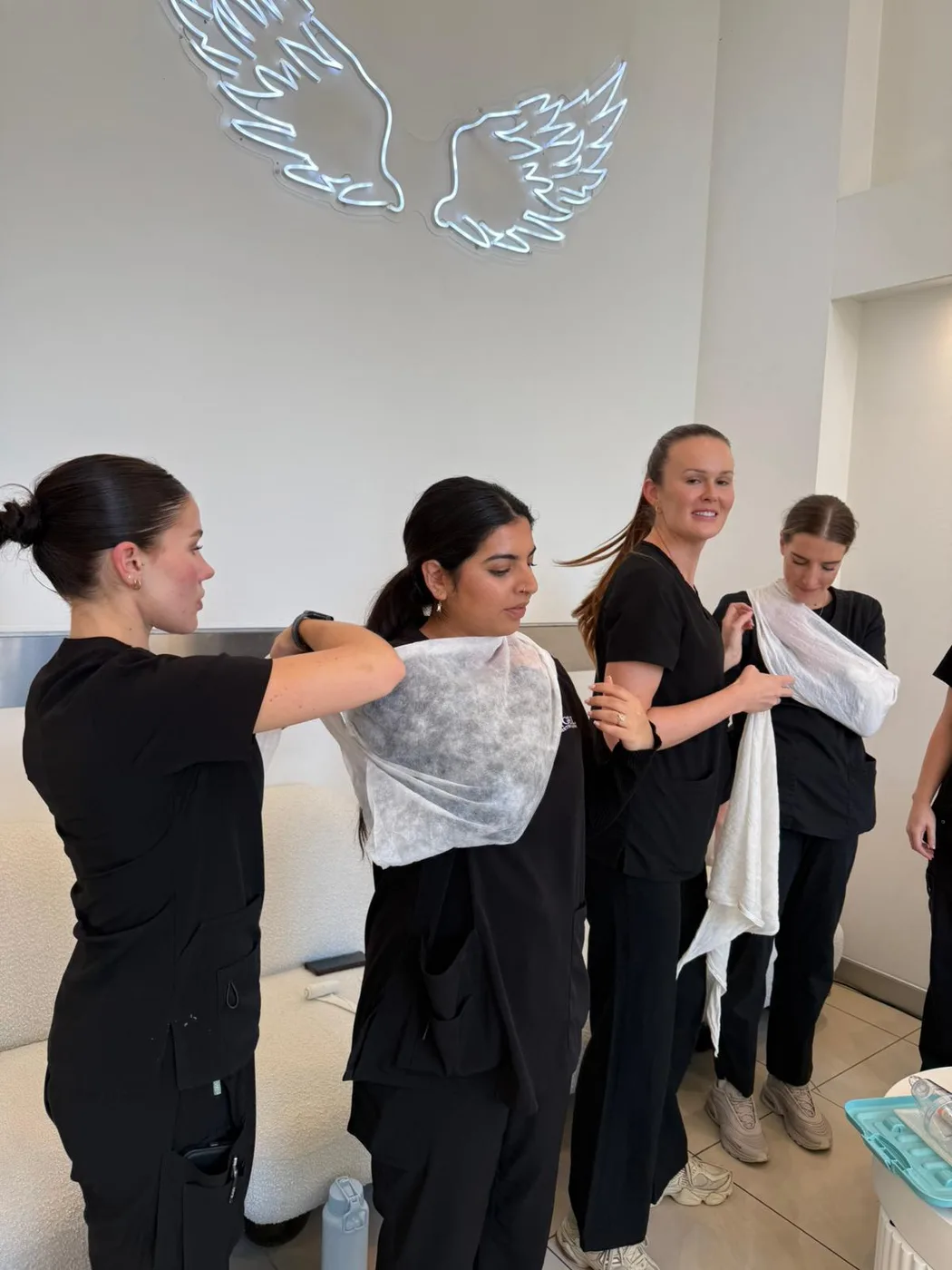Trainees practising arm sling and triangular bandage application during first aid training