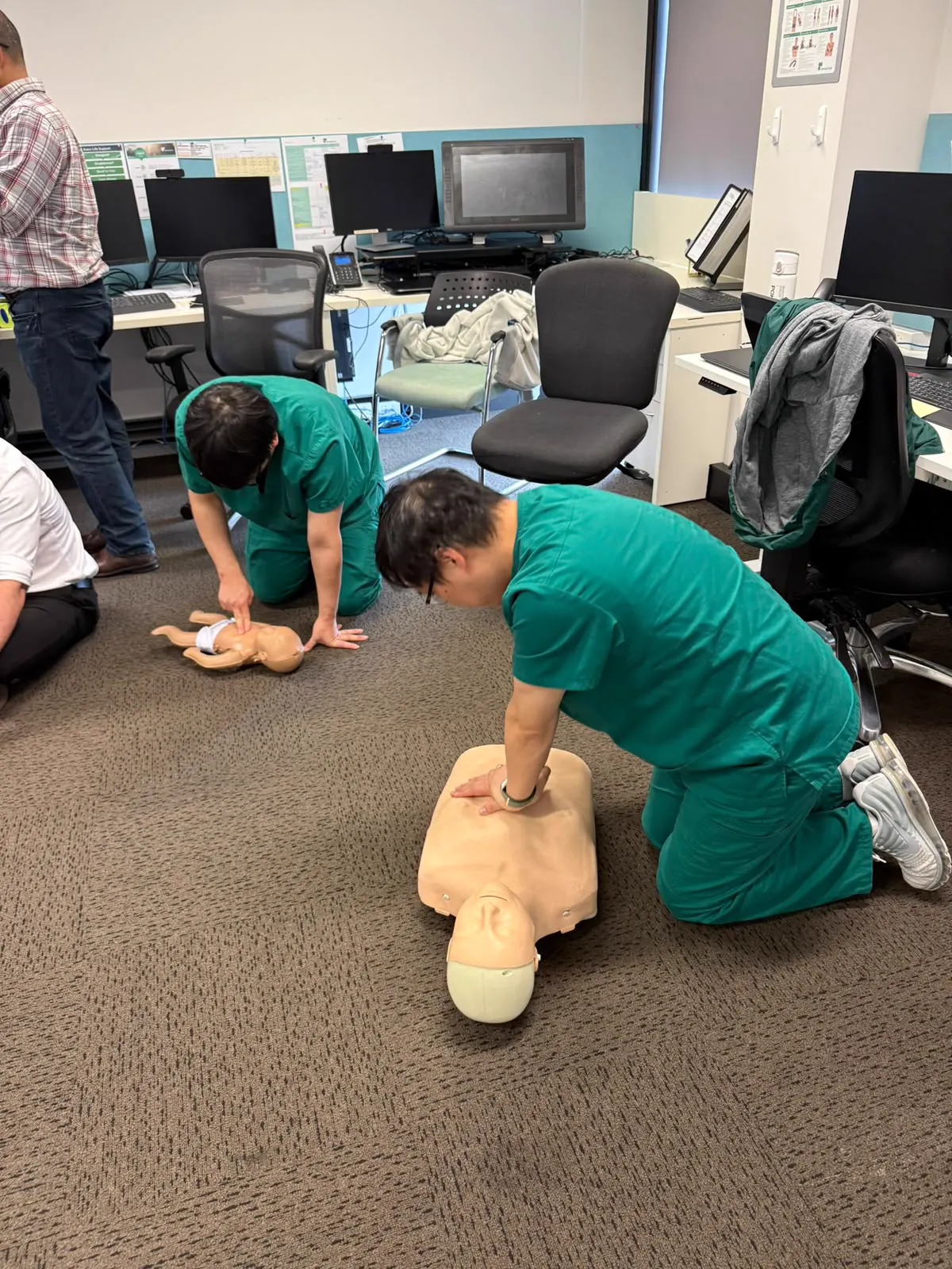 Workplace CPR practice with healthcare staff using adult and infant manikins