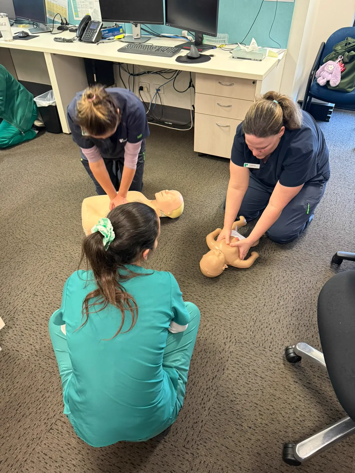 Healthcare staff practising CPR with adult and child manikins during training